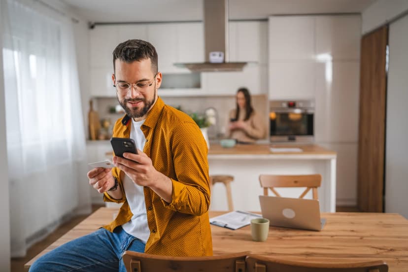 Man using calculator app in modern kitchen